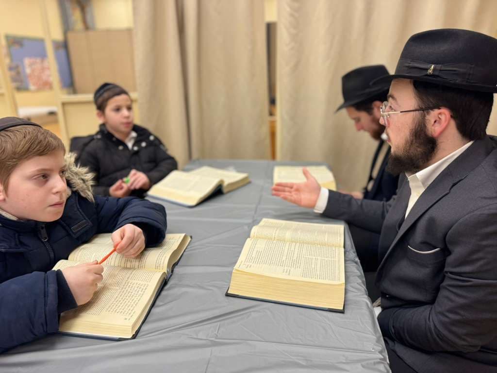 בחור ישיבה לומד בחברותא עם שני ילדים מתוך ספר קודש